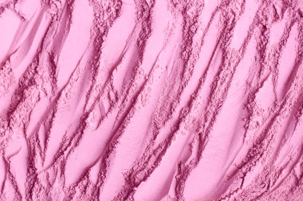 istock Rose cosmetic clay powder (alginate facial mask, body wrap, make-up blusher) texture close up, selective focus. Abstract pink pale background with brush strokes. 1301729237