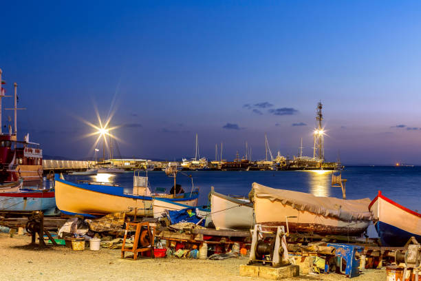 Pomorie, Bulgaria boats panorama, blue hour Pomorie, Bulgaria beachfront sea panorama with boats in the town and seaside resort on Black sea, blue hour dusk view pomorie stock pictures, royalty-free photos & images