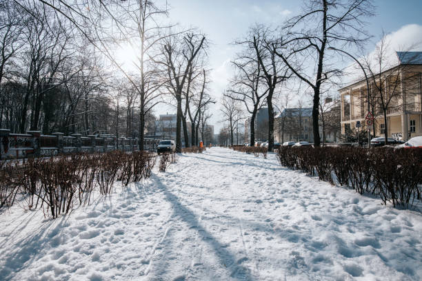 snow capped pedestrian walkway on main road in Berlin Prenzlauer Berg on sunny winter day