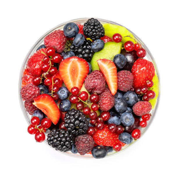 Fruit salad in glass bowl top view isolated on white. Fruit salad in glass bowl top view isolated on white background. fruit salad stock pictures, royalty-free photos & images