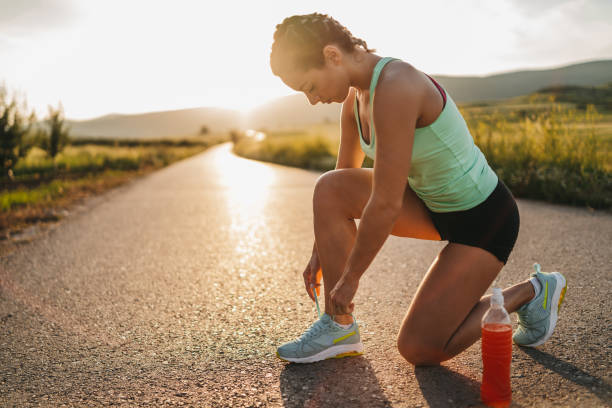 istock Female runner tying her shoes preparing for a jog 1301737076