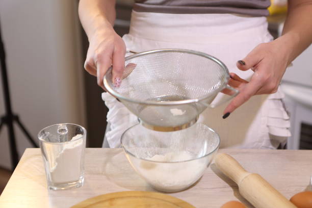 istock Girl sifting flour 1301739276