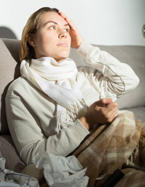 istock Young female is watching TV and sitting on sofa 1301739539