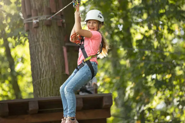 Cute little girl climbing in adventure park. This file is cleaned and retouched.