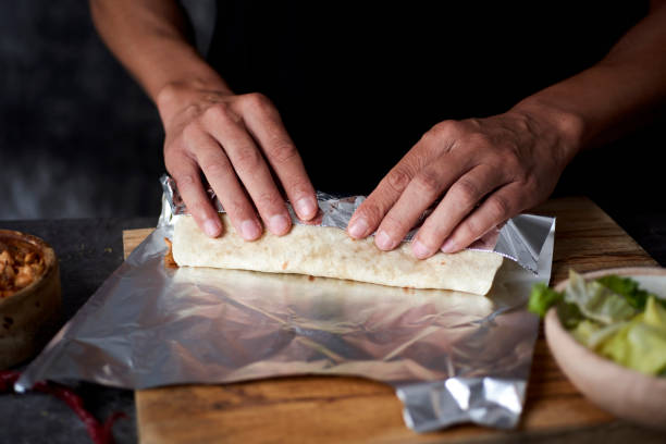 istock man wraps a durum or a burrito in aluminum foil 1301743823