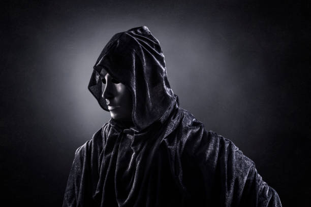 istock Scary figure with hooded cape in the dark 1301744006