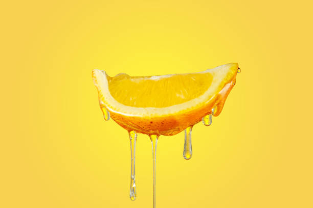 istock honey dripping slice of lemon on yellow background 1301744602