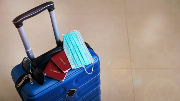 istock Blue suitcase collected for travel during the covid pandemic. Concept holidays and trips. Banner size. Copy space. Selective focus. Shallow depth of field 1301744607