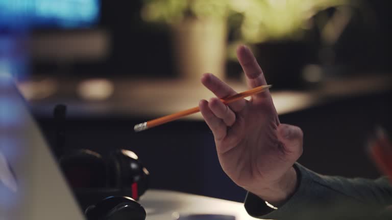 Man fidgeting a pencil while working late