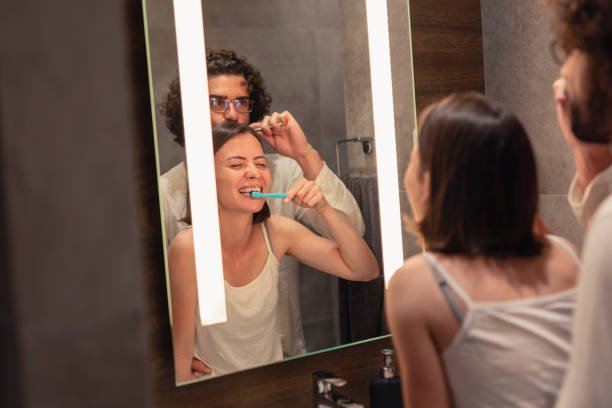 istock Couple brushing teeth in front of bathroom mirror 1301746036