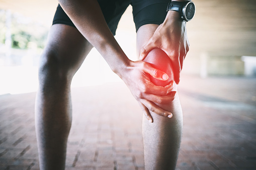 Cropped shot of a man experiencing joint pain while working out against an urban background