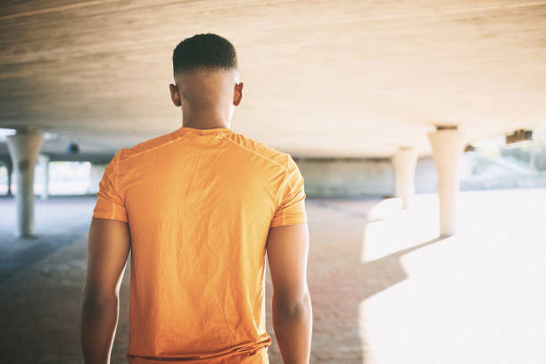 Rearview shot of a young man working out against an urban background