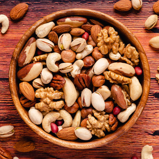 istock Various Nuts in wooden bowls 1301746985