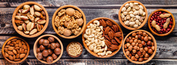 istock Various Nuts in wooden bowls 1301747035