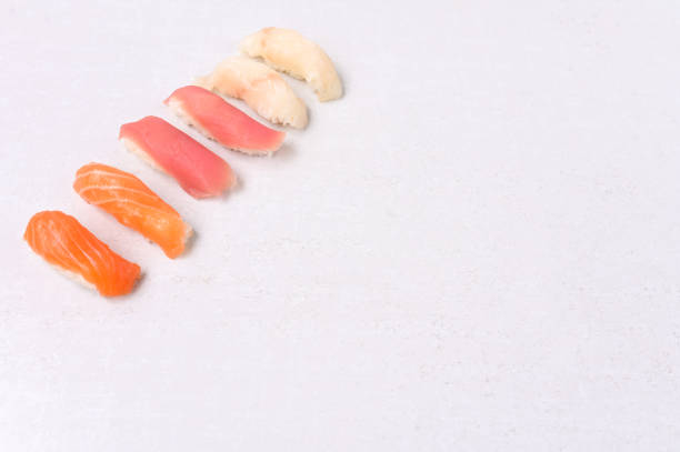 Nigiri sashimi with salmon, tuna, Seabass. Nigiri sushi set on a white background. Delicious traditional Japanese food, tasty seafood, restaurant concept, food background.