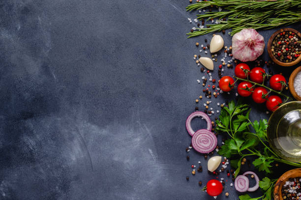 istock Herbs and condiments on black stone background. 1301747210