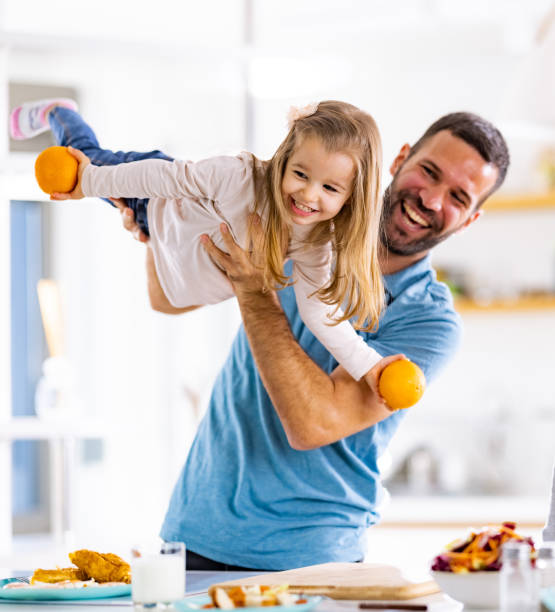 istock Cheerful single father having fun with his daughter in dining room. 1301748702