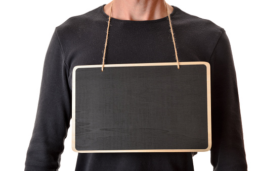 Half body detail of man in black sweater with empty banner hanging from neck. Horizontal composition.