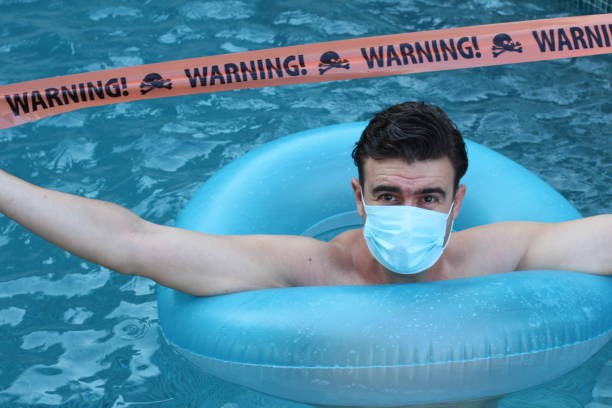 touriste stressé dans la piscine pendant la pandémie - beach cancelled close up color image photos et images de collection