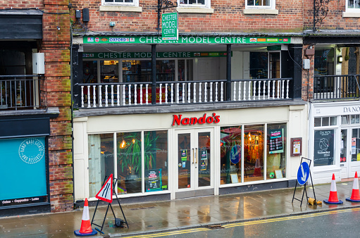 Chester; UK: Jan 29, 2021: The Bridge Street branch of Nandos Afro-Portuguese restaurant is open for delivery and take away during the corona virus pandemic lockdown.