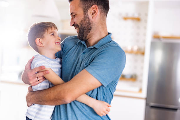 istock Affectionate single father embracing his son at home. 1301750934