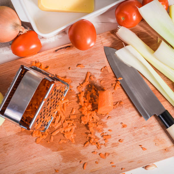 istock Vegetable grater and grated carrots on a kitchen board for preparing a vegetarian dish 1301751248