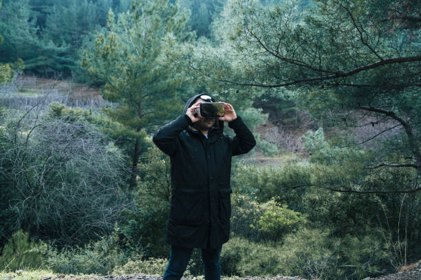 istock Man examining the forest with virtual reality glasses. Future technology vr 3D glasses to be used anywhere 1301752429