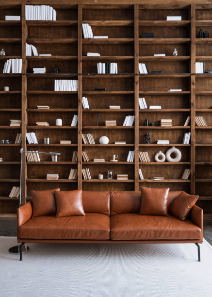 istock Room with comfortable couch and books on bookshelves 1301752430