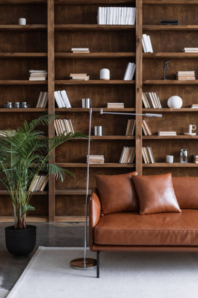 istock Room with comfortable couch and books on bookshelves 1301752437