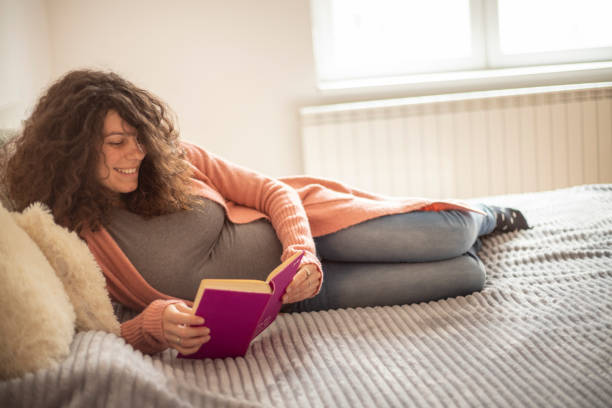 istock Pregnant woman reading a book 1301755181