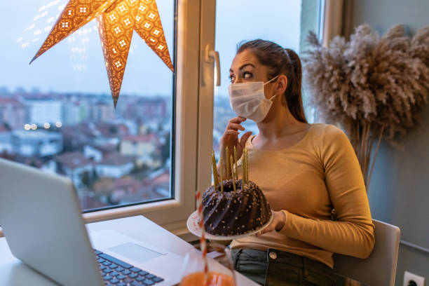 istock Young woman with protective face mask on a video call, celebrating birthday 1301756536