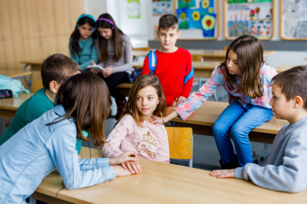 istock School children comfort their classmate in the classroom 1301757732