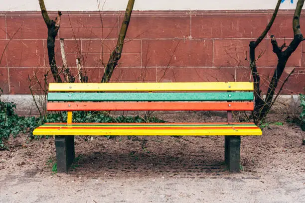 a colorful wooden bench with raindrops in the city park