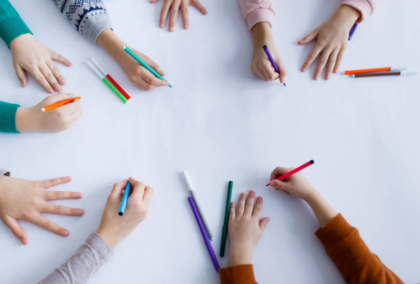 istock Children hands drawing on white paper 1301760068