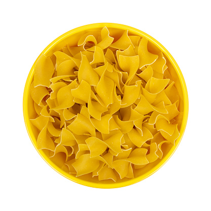 Top view of a bowl filled with no yolk wide pasta isolated on a white background.