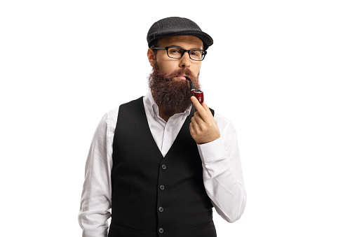 Bearded man with glasses and hat smoking a pipe isolated on white background