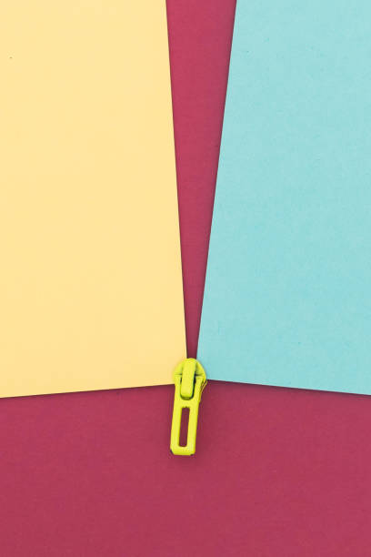 istock blue and yellow cardboards joined by a zipper on a pink background 1301763324