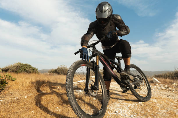 istock Downhill rider fully equipped with protective gear and his bicycle 1301764559