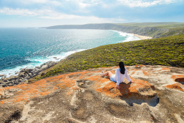 woman sitting on the edge of the cliff , kangaroo island, south australia - travel scenics landscape observation point imagens e fotografias de stock