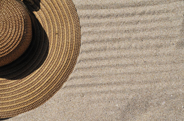 istock Hat and sun cream protection on sand. Summer time concept. 1301765331