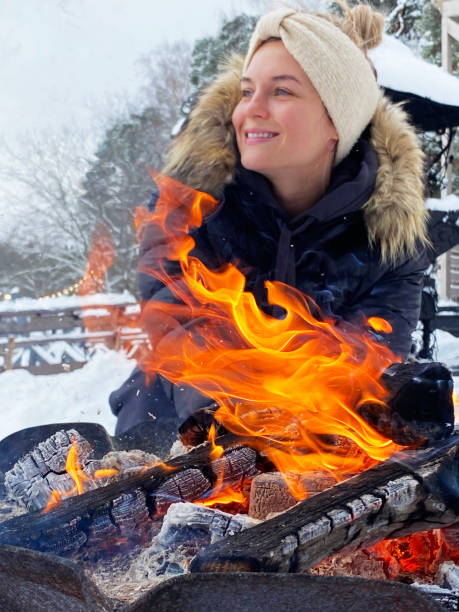 istock Young woman warming up by the fire pit during cold winter day 1301765694
