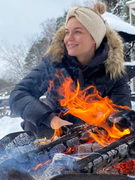 istock Young woman warming up by the fire pit during cold winter day 1301765711