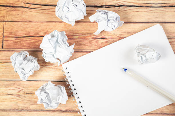istock Paper balls and pen over blank white sheet - Creativity crisis concept 1301765776