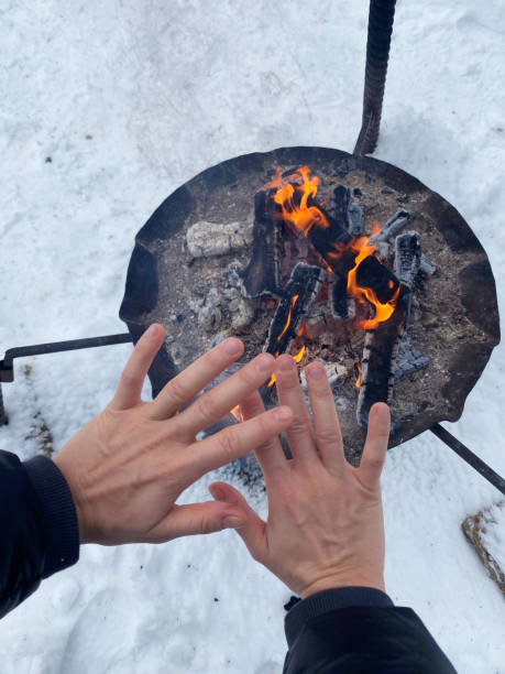 istock Woman warming up her hands by the fire pit 1301765887