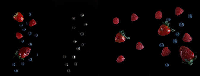 pouring fruit - raspberry, blueberry and strawberry against black background. Image contains copy space