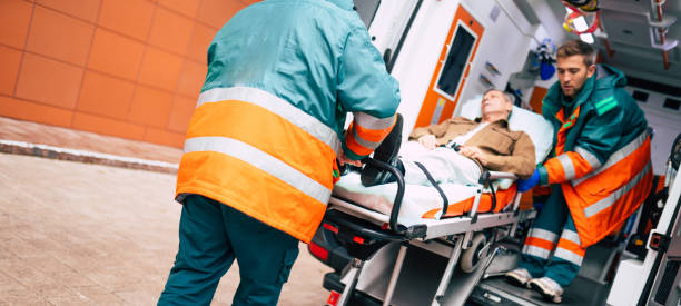 istock Confident and professional doctors unloading an ill patient from an ambulance car on a stretcher near the hospital building 1301767408