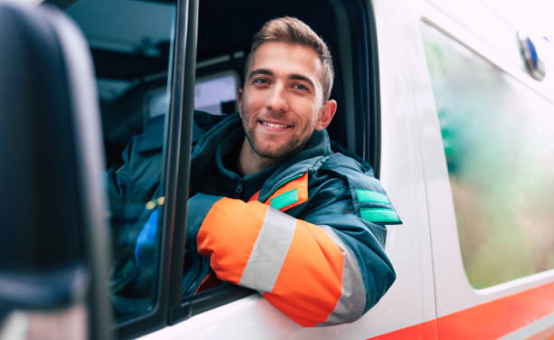 Professional and confident young man doctor looking on the camera with ambulance background stock photo
