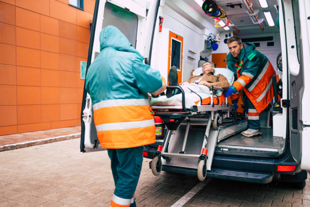 istock Confident and professional doctors unloading an ill patient from an ambulance car on a stretcher near the hospital building 1301768667