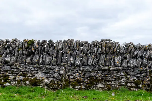 Photo of Dry stone wall with grass and sky