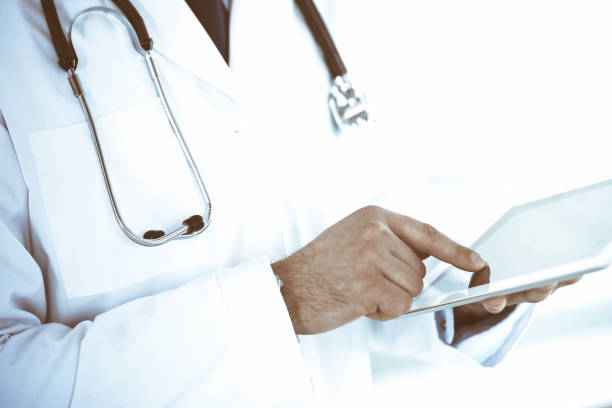 istock Doctor man using tablet computer for network research or virtual disease treatment, hands close-up. Perfect medical service in clinic. Modern medicine, medic data and healthcare concepts. Toned picture 1301772699